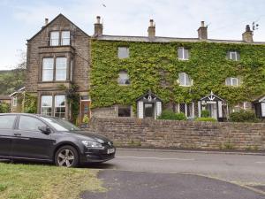 a car parked in front of a house with ivy at Easter Cottage in Bamford