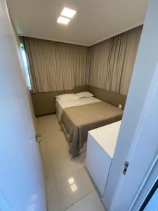 a small bedroom with a bed and a white cabinet at Beach Class Muro Alto 6308 in Porto De Galinhas +14 photos