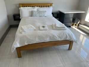 Una cama con sábanas blancas y toallas. en Exquisite Galway City Luxury home – Sleeps 10 en Galway