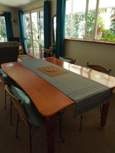 a wooden table in a room with chairs around it at Garden Studio in Jaggan