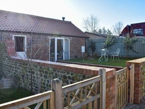 a brick house with a wooden fence and a yard at Primrose in Scruton