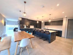 a large kitchen with a wooden table and chairs at Exquisite Galway City Luxury home – Sleeps 10 in Galway
