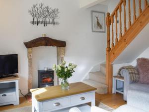 a living room with a vase of flowers on a table at Lavender Cottage in Leyburn