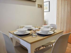 a dining room table with bowls and glasses on it at Lavender Cottage in Leyburn