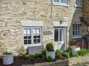 a stone house with plants in front of it at Lavender Cottage in Leyburn