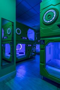 una habitación con luces verdes y azules y una silla en OXYGEN HOSTEL Capsula, en Madrid