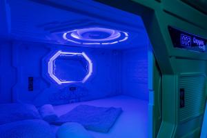 Habitación con 2 camas y luz azul en OXYGEN HOSTEL Capsula, en Madrid