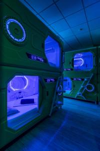 Habitación con luces verdes y azules en un buque espacial en OXYGEN HOSTEL Capsula, en Madrid