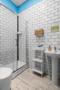 baño blanco con ducha y lavamanos en OXYGEN HOSTEL Capsula, en Madrid