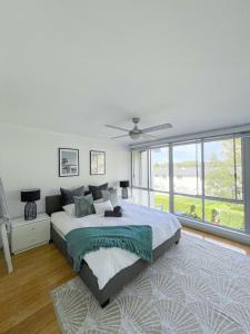 a bedroom with a large bed with a ceiling fan at Belle by the Bay in Fingal Bay