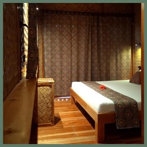 - une chambre avec un lit et un banc dans l'établissement At Home, à Puerto Princesa