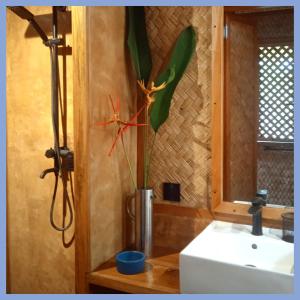 a plant in a vase next to a sink at At Home in Puerto Princesa City