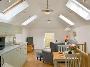 a kitchen and living room with a table and chairs at Ladyvale Barn in Cardinham