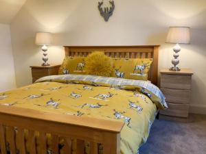 a bedroom with a bed with a yellow comforter at Balmore Farmhouse in Lochend