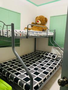 a teddy bear sitting on top of a bunk bed at Holiday House near Butuan City Airport in Butuan