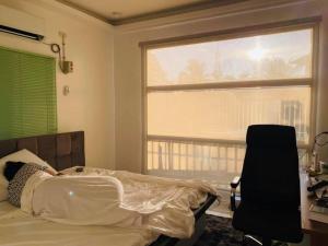 a bedroom with a bed and a desk and a window at Holiday House near Butuan City Airport in Butuan