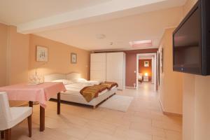 a bedroom with a bed and a table and a television at Hotel Herzog in Düsseldorf