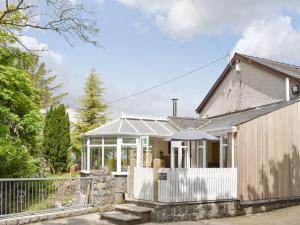 a home with a white fence and a house at Tan Yr Ardd Bach in Llanwnda