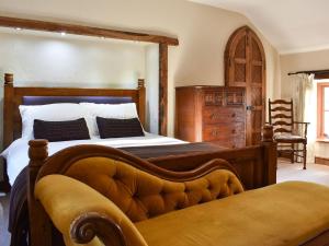 a bedroom with a large bed with a wooden frame at The Barracks in Little Strickland