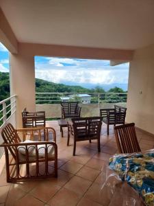 Habitación con sillas y balcón con vistas. en grand studio en bas de villa avec vue sur mer au Carbet, en Le Carbet