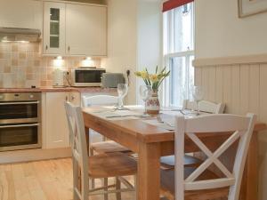 a kitchen with a wooden table with white chairs and a table and chairsktop at Crofts in Badenyon