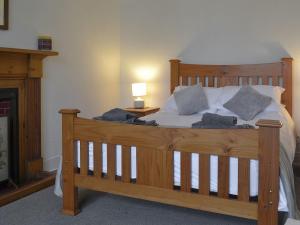 een slaapkamer met een houten bed met kussens erop bij Crofts in Badenyon