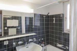 ein Bad mit einem Waschbecken und einem Spiegel in der Unterkunft Hotel Provisorium13 in Arosa