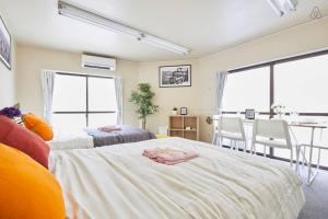 ein Schlafzimmer mit 2 Betten und ein Esszimmer in der Unterkunft TORA HOTEL Tokyo-kitaueno 寅ホテル北上野 in Tokio