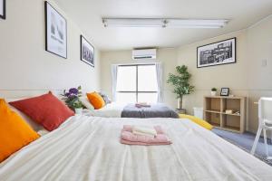ein Schlafzimmer mit einem großen Bett mit Handtüchern darauf in der Unterkunft TORA HOTEL Tokyo-kitaueno 寅ホテル北上野 in Tokio