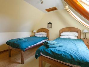 two twin beds in a room with a window at The Smiddy - S4278 in Lochearnhead