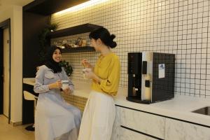 two women standing in a kitchen talking at Z Hotel in Petaling Jaya