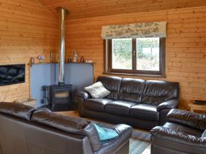 a living room with leather furniture and a fireplace at Dartmoor - Uk12537 in Witheridge