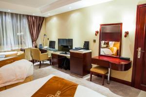 um quarto de hotel com uma secretária e um espelho em Grand Legacy Hotel em Kigali