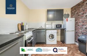 a kitchen with a refrigerator and a washer and dryer at THE LAW, Guest FAVOURITE, 4 Rooms with TVs, Central, Free Parking, Fully Equipped, 2 Bathrooms, Long Stay Rates Available by SUNRISE SHORT LETS in Dundee