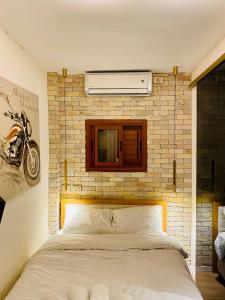 Cama en habitación con pared de ladrillo en Sunset TLV Apartment - Dizengoff 142, en Tel Aviv