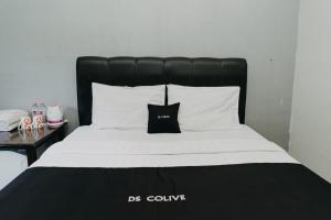 a bed with a black headboard and white pillows at DS Colive 34 in Semarang