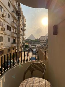 een balkon met een tafel en uitzicht op de piramides bij Asma Pyramids View in Caïro
