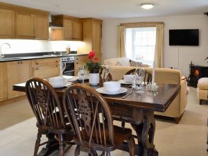 een keuken en eetkamer met een houten tafel en stoelen bij The Mill in Tregaron