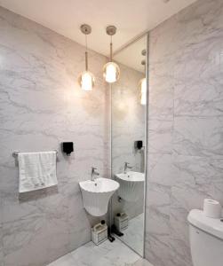 ein weißes Badezimmer mit 2 Waschbecken und einem Spiegel in der Unterkunft Infinity Guesthouse in Semporna