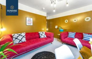 2 sofás rojos en una sala de estar con paredes amarillas en 3 BED LAW, 3 rooms, 1 Bathroom, Free Parking, WiFi, Sleeps 4, Contractors, Tourists, Relocation, Business, Travellers, Short - Long Stay Rates Available by SUNRISE SHORT LETS, en Dundee