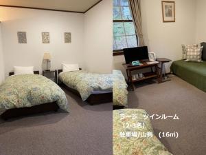 a bedroom with two beds and a desk with a tv at Guesthouse Kreutzer in Chino