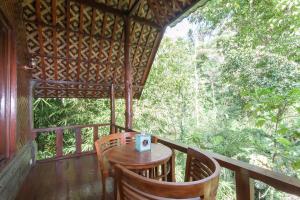 a table and chairs on the porch of a cabin at Bali Jungle Resort in Tegalalang