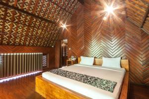 a bedroom with a bed and a wooden wall at Bali Jungle Resort in Tegalalang