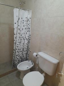 a bathroom with a toilet and a shower curtain at Caseros Centro in San Juan