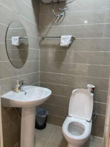 a bathroom with a toilet and a sink and a mirror at Cozy 3 bedroom flat in serene gated Ikoyi Estate in Lagos