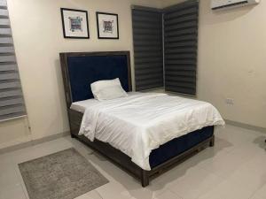 a bedroom with a large bed with white sheets at Cozy 3 bedroom flat in serene gated Ikoyi Estate in Lagos
