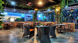 a restaurant with tables and chairs in a room at SOVRANO HOTEL BATAM fka PARKSIDE SOVRANO HOTEL in Nagoya