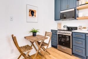 a kitchen with blue cabinets and a table and chairs at Soleil House - Unit C in Galveston