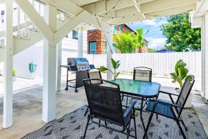 a patio with a table and chairs and a grill at Soleil House - Unit C in Galveston