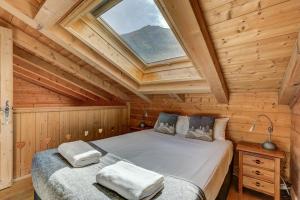 La Cloche des Bois - Alpes Travel - Les Bois - Sleeps 4-6 في شامونيه مون بلان: غرفة نوم بسريرين في كابينة خشبية